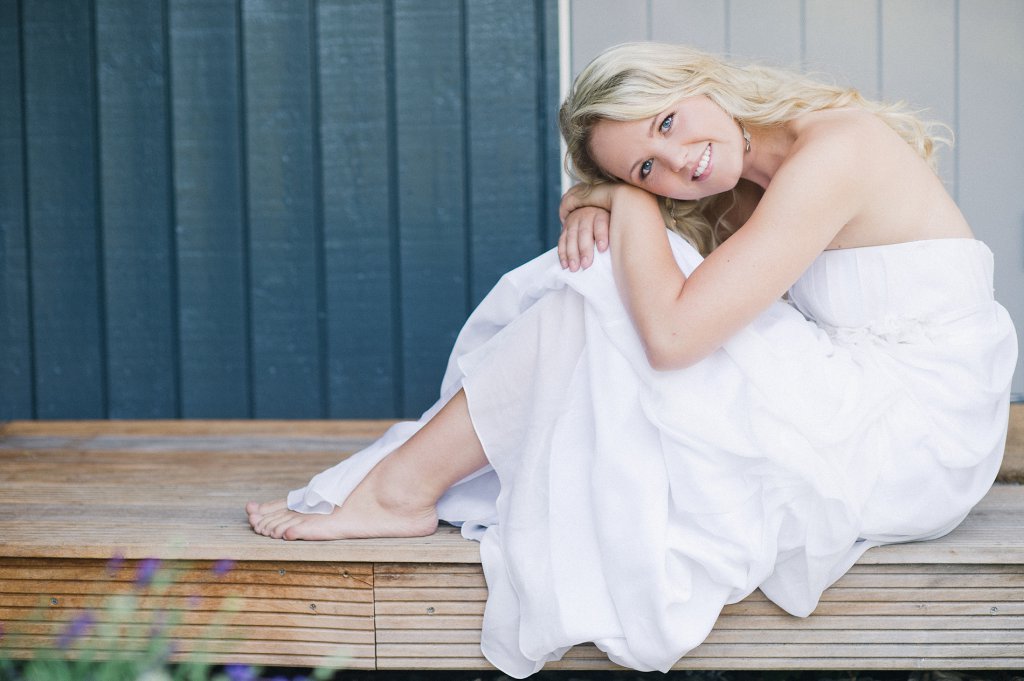 Photo Braut sitzt auf Verandatreppe.